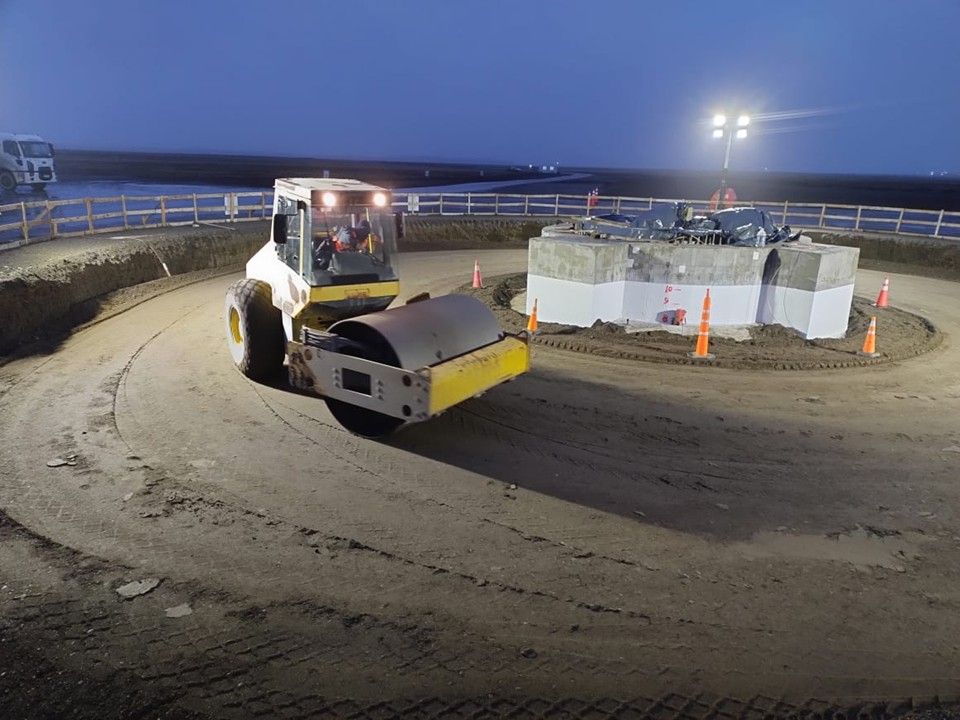 Rodillo compactador trabajando de noche con iluminación de obra